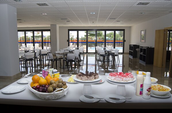 A buffet table with various food items and a view of outdoor seating. - Hotel Adaria Vera (Vera)