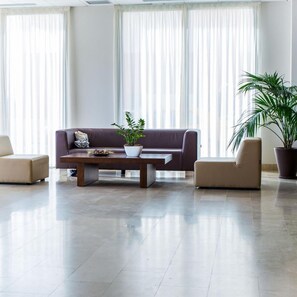 A modern living room with a sofa, two armchairs, a coffee table, and two potted plants. - Hotel Adaria Vera (Vera)