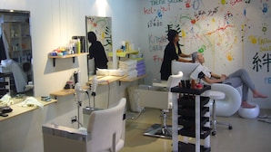 A salon with a modern interior, including a hairdressing station and a client seated in a chair. - Himalaya Residence (Bangkok)