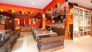 A restaurant with multiple seating areas, including booths and tables, and a display cabinet with various items. - Himalaya Residence (Bangkok)