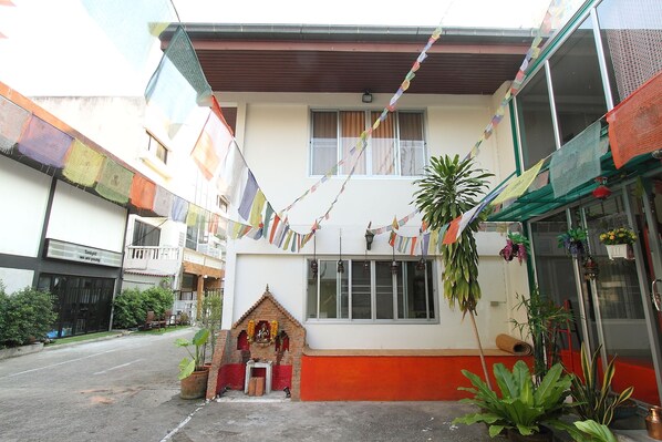 A building with a small shrine, a balcony, and a window.