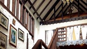 A staircase with wooden railings leading to a dining area with tables and chairs. - The Bala's Holiday Chalet (Tanah Rata)