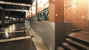 A hotel entrance with a checkered floor, a staircase, and a sign indicating the hotel name.