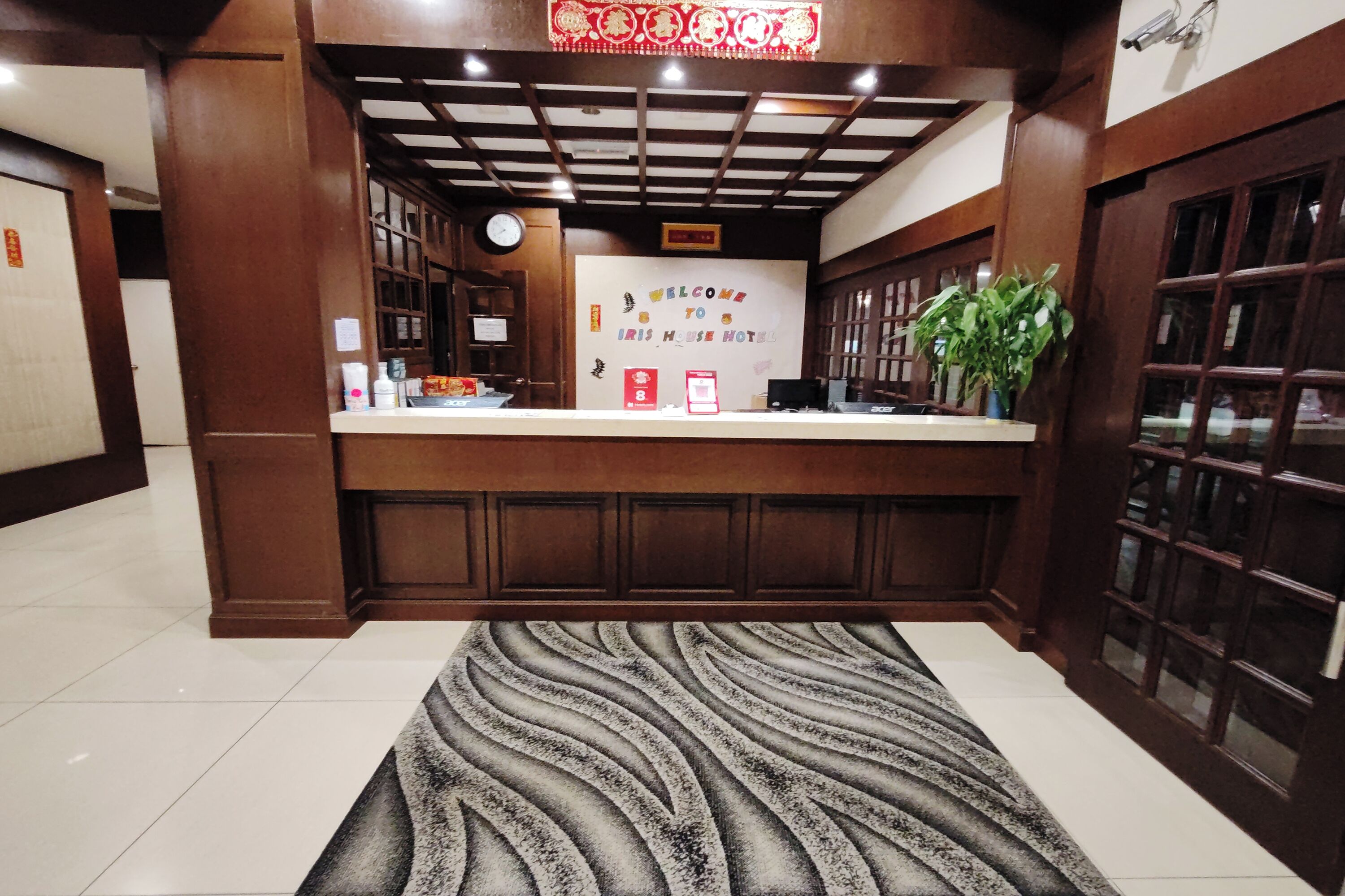 A reception area with a check-in counter, a clock, and a welcome sign.