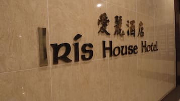 Un cartello con il nome 'Rís House Hotel' scritto sia in inglese che in un'altra grafia.