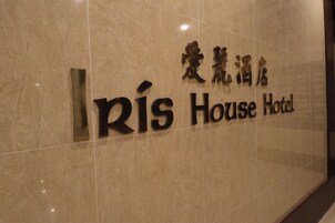 Un cartello con il nome 'Rís House Hotel' scritto sia in inglese che in un'altra grafia.