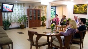 A room with a television, a cabinet, and several potted plants. - Hillview Inn (Tanah Rata)