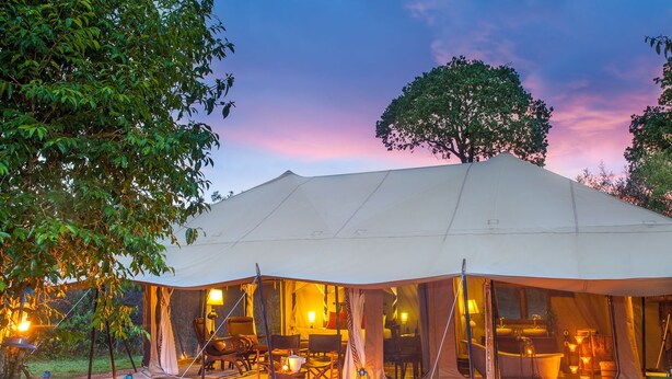 A large tent with a dining area and a bathroom visible through the windows.