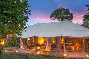 A large tent with a dining area and a bathroom visible through the windows. - Mara Ngenche Safari Camp (Maasai Mara)