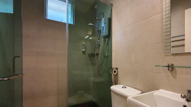A bathroom with a glass-enclosed shower, a toilet, and a sink with a glass shelf above it. - Arundina Cameron Highlands (Tanah Rata)