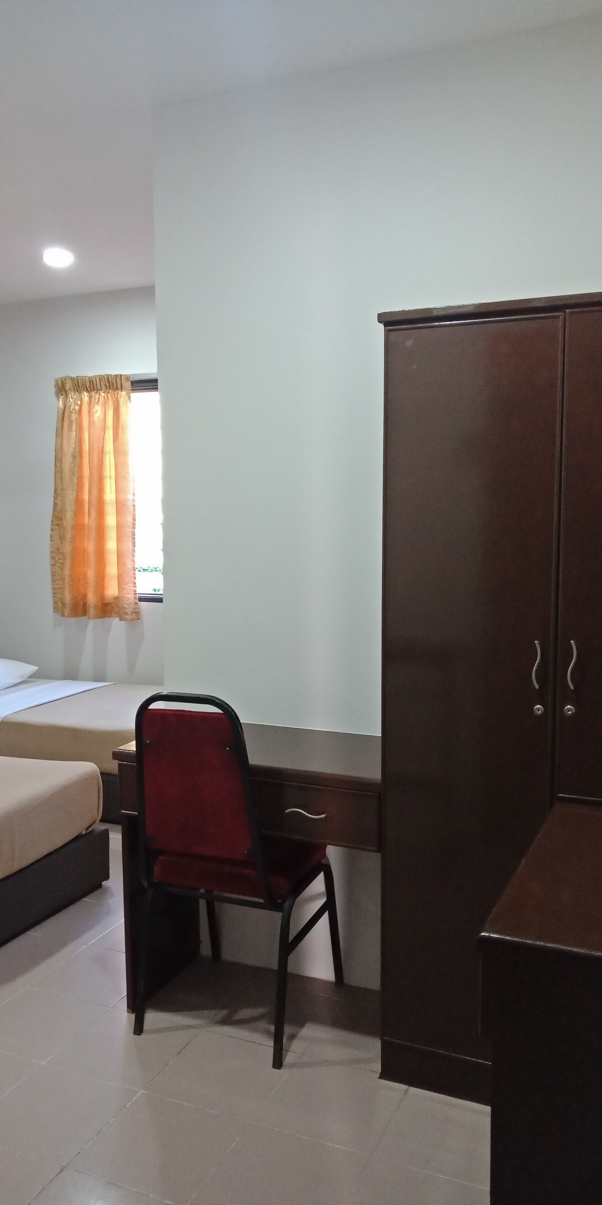 A bedroom with a bed, a desk, a chair, and a wardrobe.
