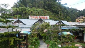 Un jardín con un letrero que dice "TWIN PINE'S" y un cartel de recepción.