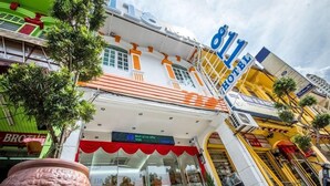 A hotel with a prominent '811' sign, a red awning, and a large potted plant in the foreground. - 118 Hotel (George Town)