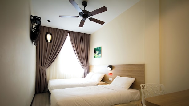 A hotel room with two beds, a ceiling fan, a wall-mounted TV, and a window with curtains. - 118 Hotel (George Town)