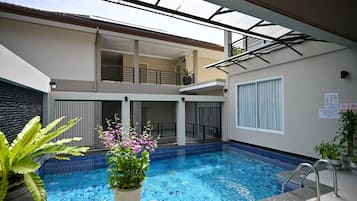 Una piscina al aire libre, tumbonas