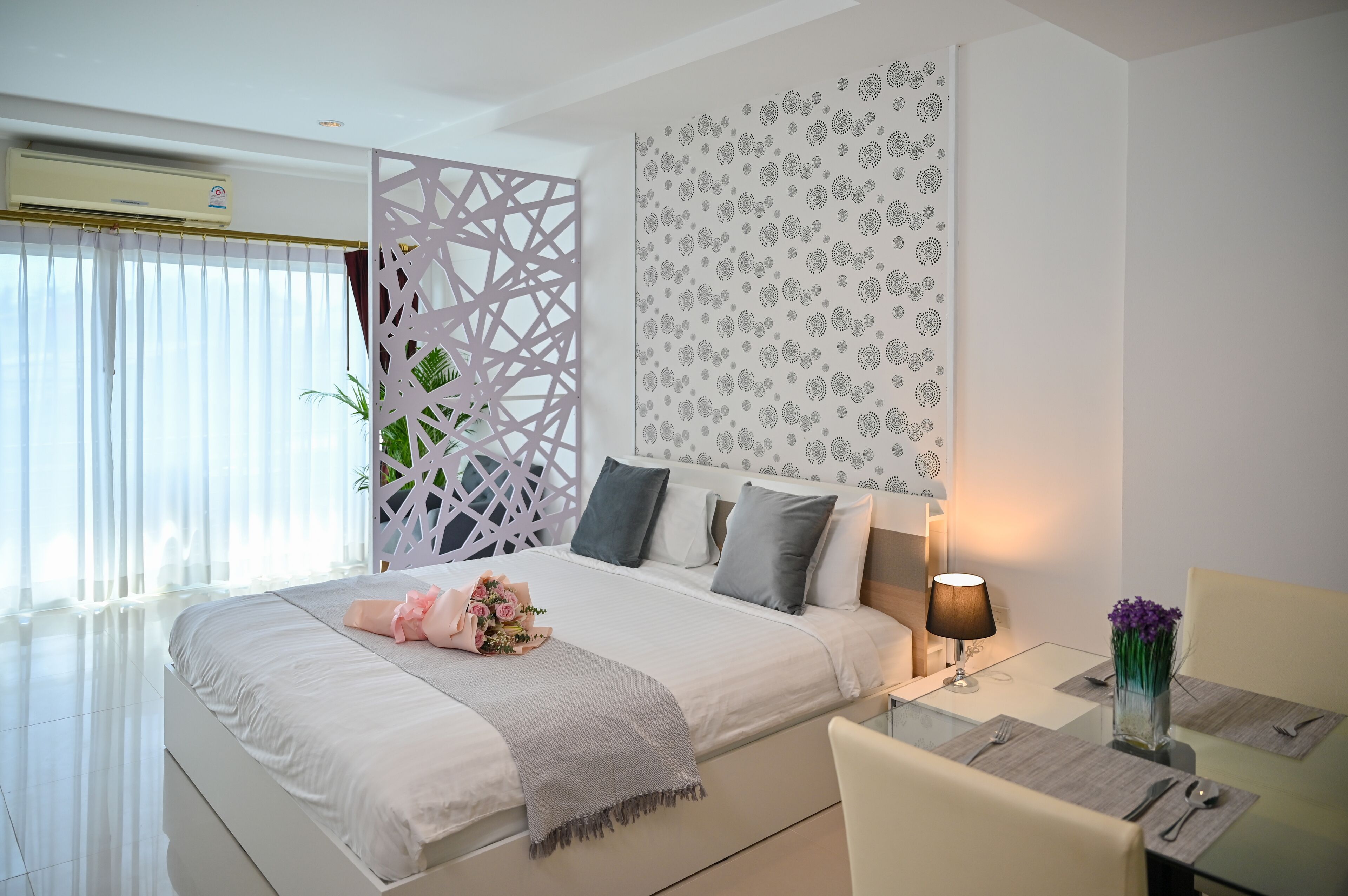 Una habitación de hotel moderna con una cama grande, un área de comedor y un adorno de pared.
