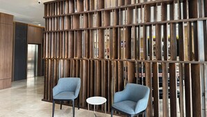 A modern interior with a wooden partition, two armchairs, and a small table. - Citadines Connect Airport Jakarta (Jakarta)