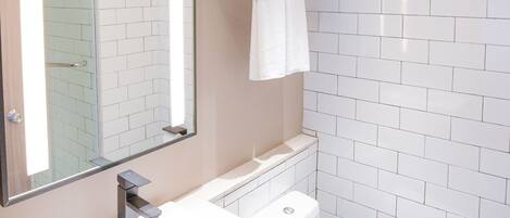 Un baño moderno con lavamanos, inodoro y cabina de ducha de vidrio.