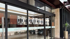 A modern hotel lobby with glass doors, a seating area with chairs, and a potted plant. - Citadines Connect Airport Jakarta (Jakarta)
