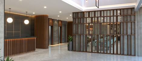 A spacious lobby with a reception desk, modern lighting fixtures, and a view of the dining area.