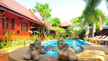 Alberca al aire libre, sombrillas en la alberca y camastros