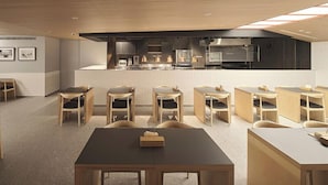 A modern dining area with wooden tables and chairs, a kitchen in the background, and a clean, minimalist design. - Red Dot Hotel (Taichung)