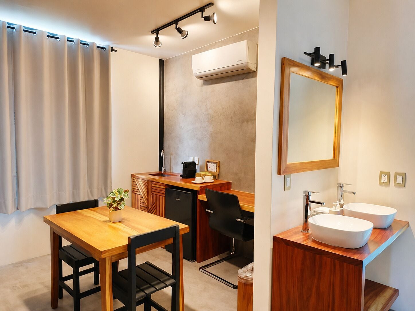 A modern bathroom with a large mirror, two sinks, and a shower area.