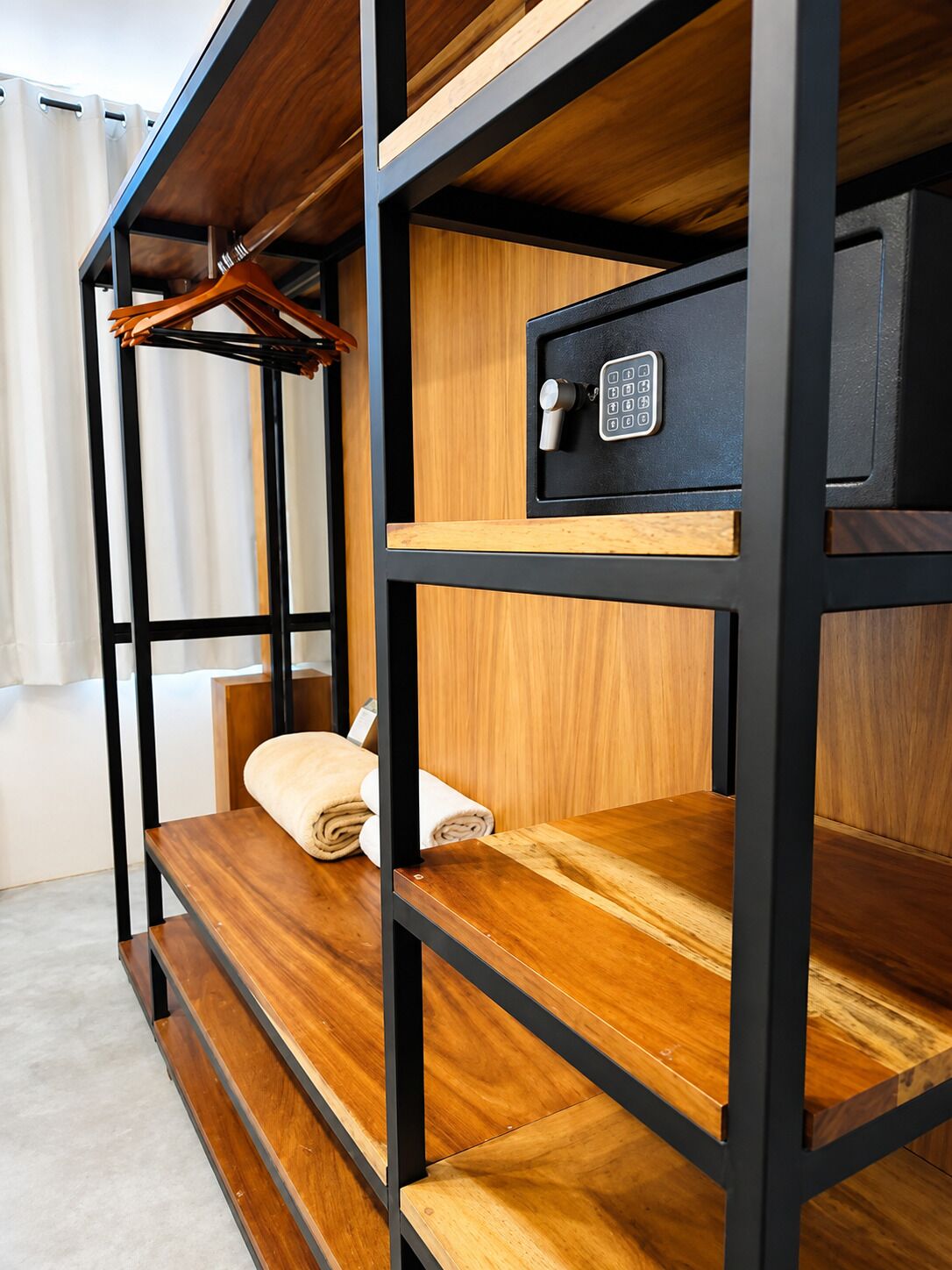 Una cama litera con caja fuerte integrada y una toalla en la litera inferior.