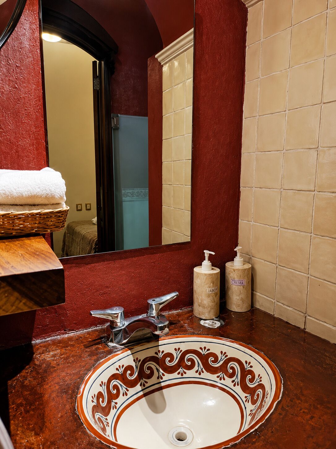 A bathroom with a marble sink, a mirror, a towel rack, and toiletries.
