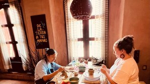 A dining area with a wooden table set for two, surrounded by various bowls and cups. - Hotel Casa del Sótano (Oaxaca)