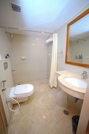 Baño pequeño y funcional con inodoro, lavamanos y ducha.