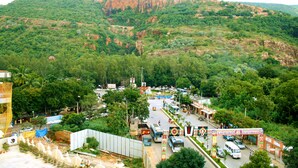 Un pueblo con una calle principal, autobuses y montañas al fondo.