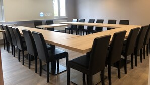 A conference room with a long table and chairs, a projector screen, and a window with daylight. - Champ'Alsace Centre (Haguenau)