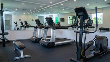 A gym with treadmills, elliptical machines, and weight benches.