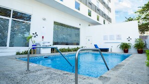 A modern building with a swimming pool, large windows, and potted plants. - Holiday Inn Express Managua by IHG (Managua)