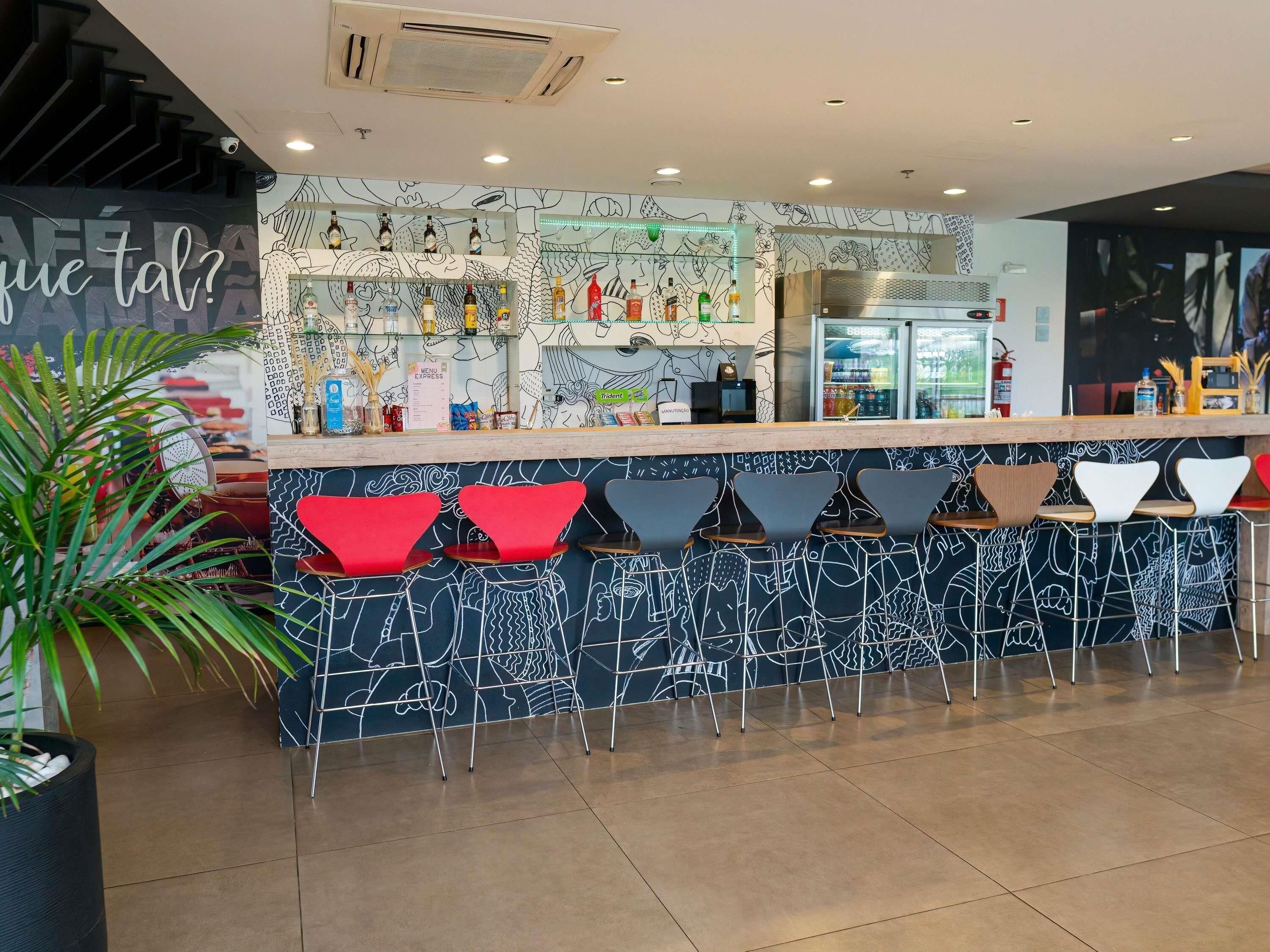 Zona de bar con mostrador, varias botellas y un panel de menú.