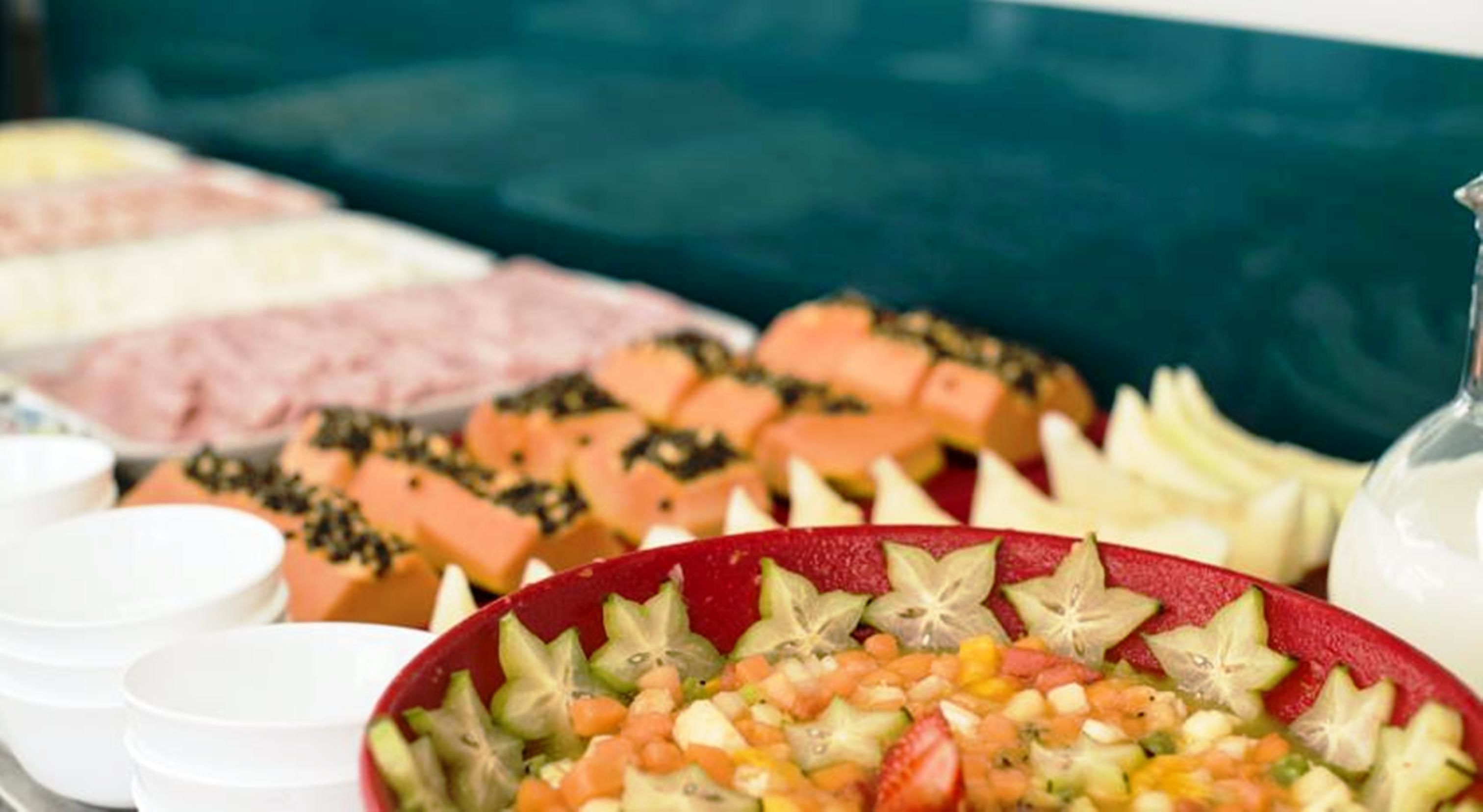 Un bufé con diferentes opciones de comida, incluyendo frutas, verduras y posiblemente algunos platos de carne.