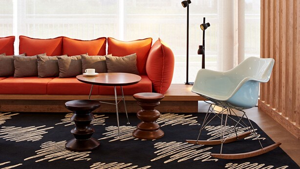A modern living room with a red sofa, a round table, a rocking chair, and a floor lamp. - ibis Londrina Shopping (Londrina)