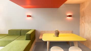 A modern room with a green sofa, a yellow table, and a cactus on the table.