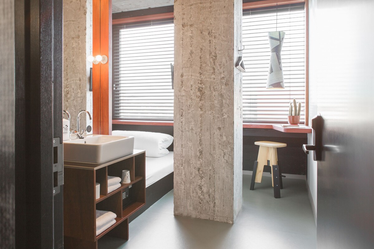 Un baño moderno con lavamanos, espejo y estanterías de madera.
