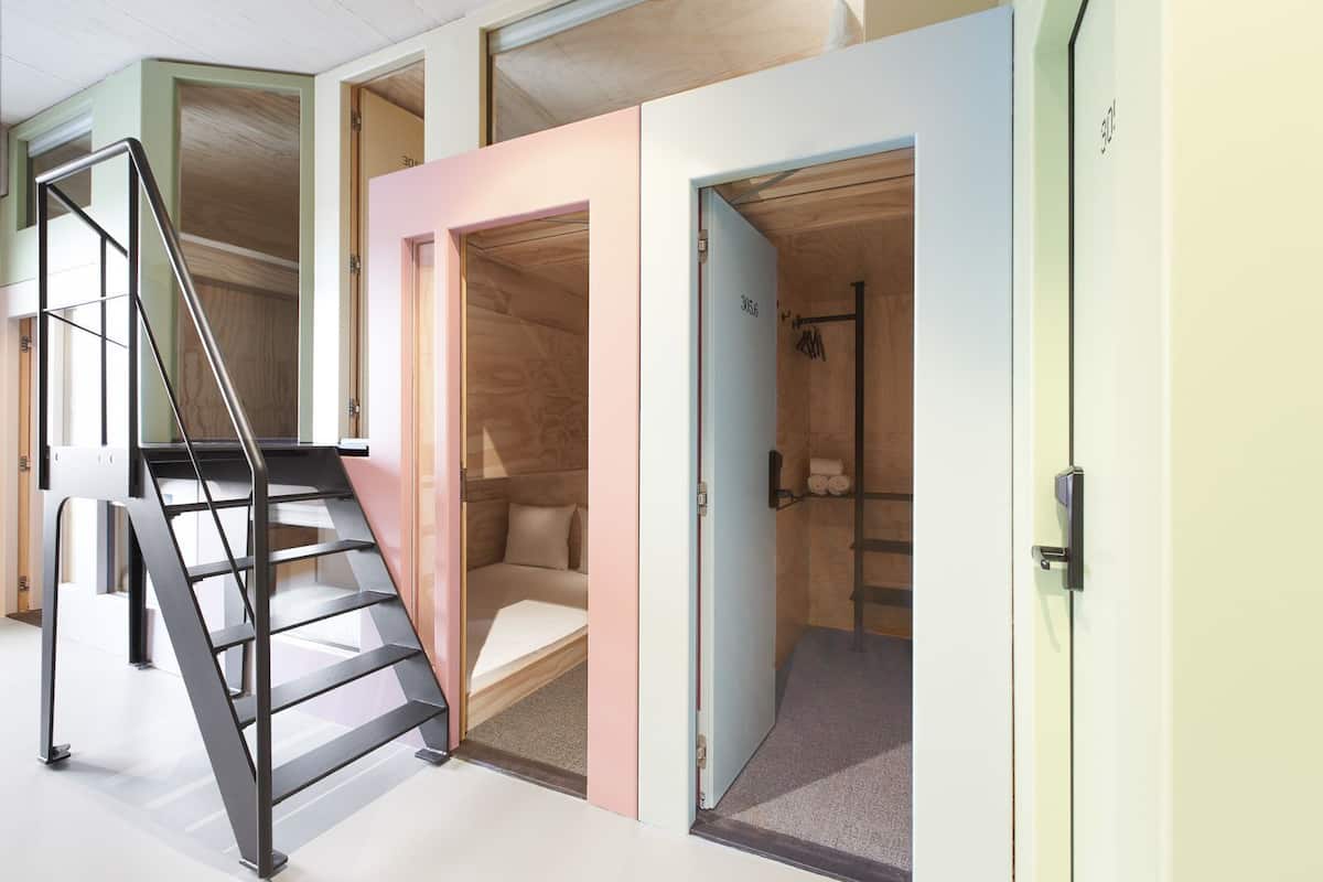 Un interior moderno con una escalera, un pequeño rincón de estar y una ducha.