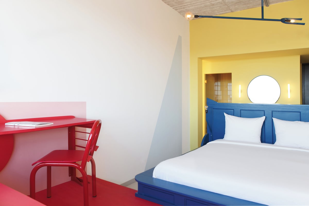A room with a bed, a desk, and a chair.