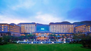 A large hotel with multiple buildings, a central entrance, and a well-maintained lawn with a pool area. - The Westin Zhujiajian Resort, Zhoushan (Zhoushan)