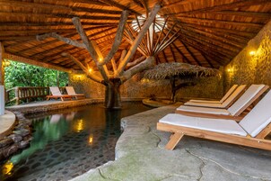Una piscina cubierta, una piscina al aire libre, tumbonas