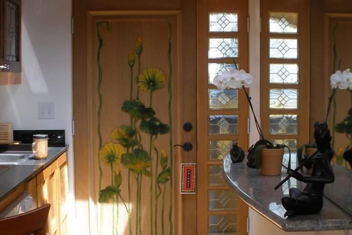A kitchen with wooden cabinets, a countertop, and a window with a view.
