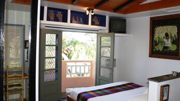 Un dormitorio con una cama, una ventana con vistas y una puerta que da a un espacio exterior.