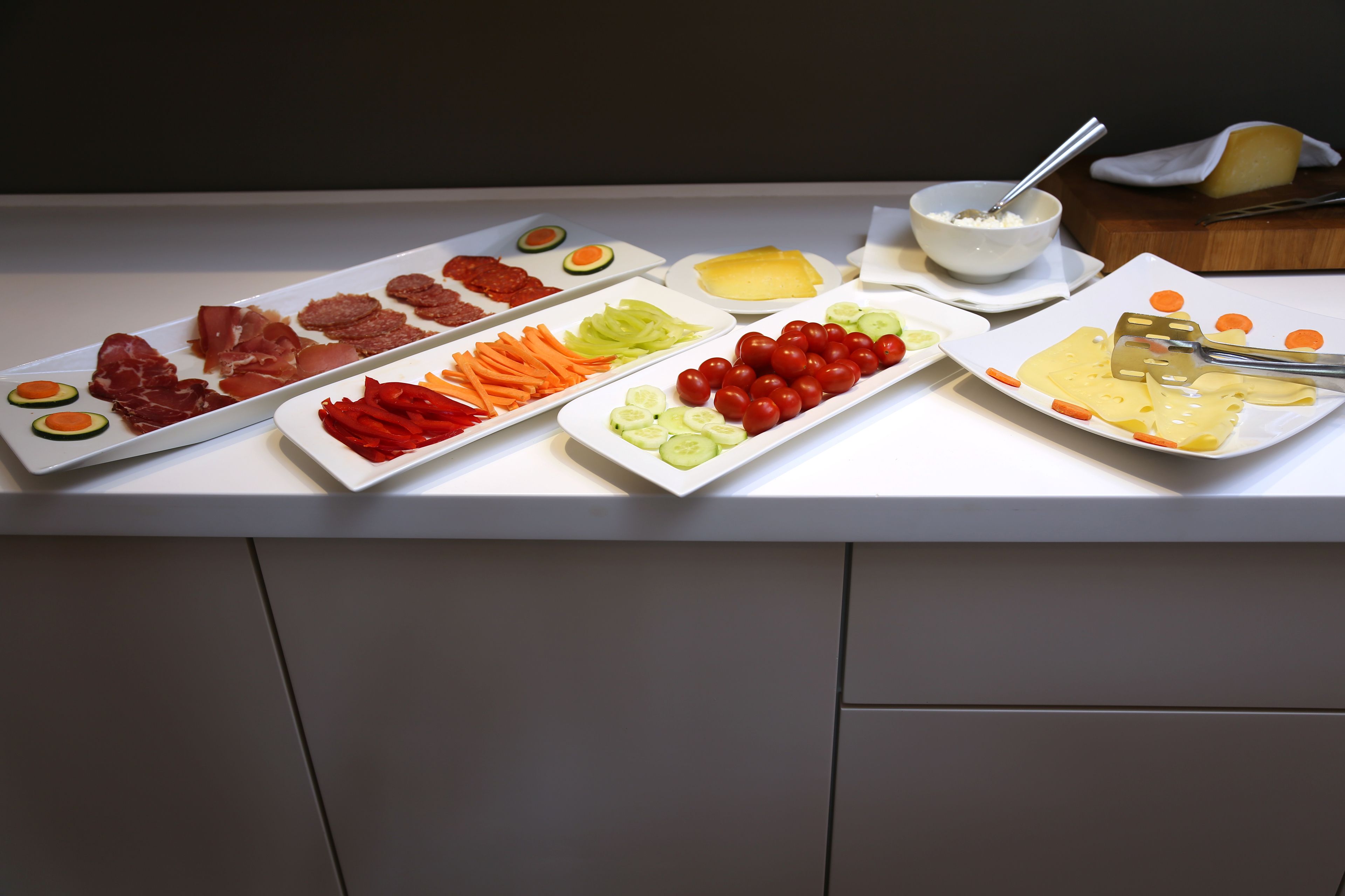 Een buffet met diverse soorten eten, waaronder vlees, groenten en kaas.