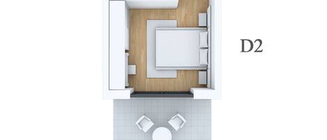 A 2D floor plan of a D2 room with a kitchenette, a bed, and a small seating area.