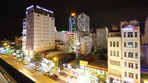 A cityscape at night with illuminated hotel signs, including "Bac Cuong Hotel" and "Hanoi Blue Hotel." - SOCO Hotel (Da Nang)