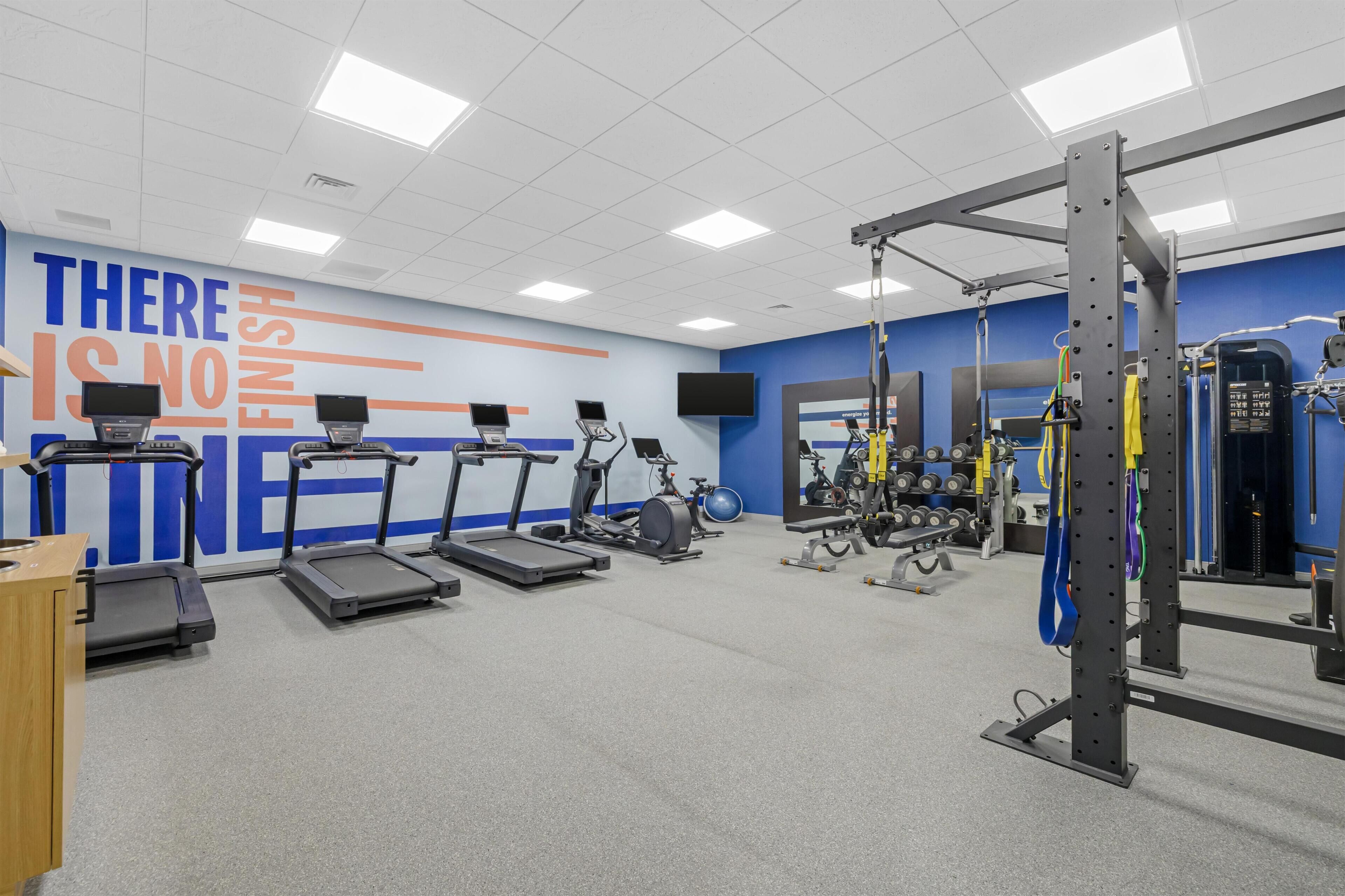 A gym with treadmills, stationary bikes, and weightlifting equipment.
